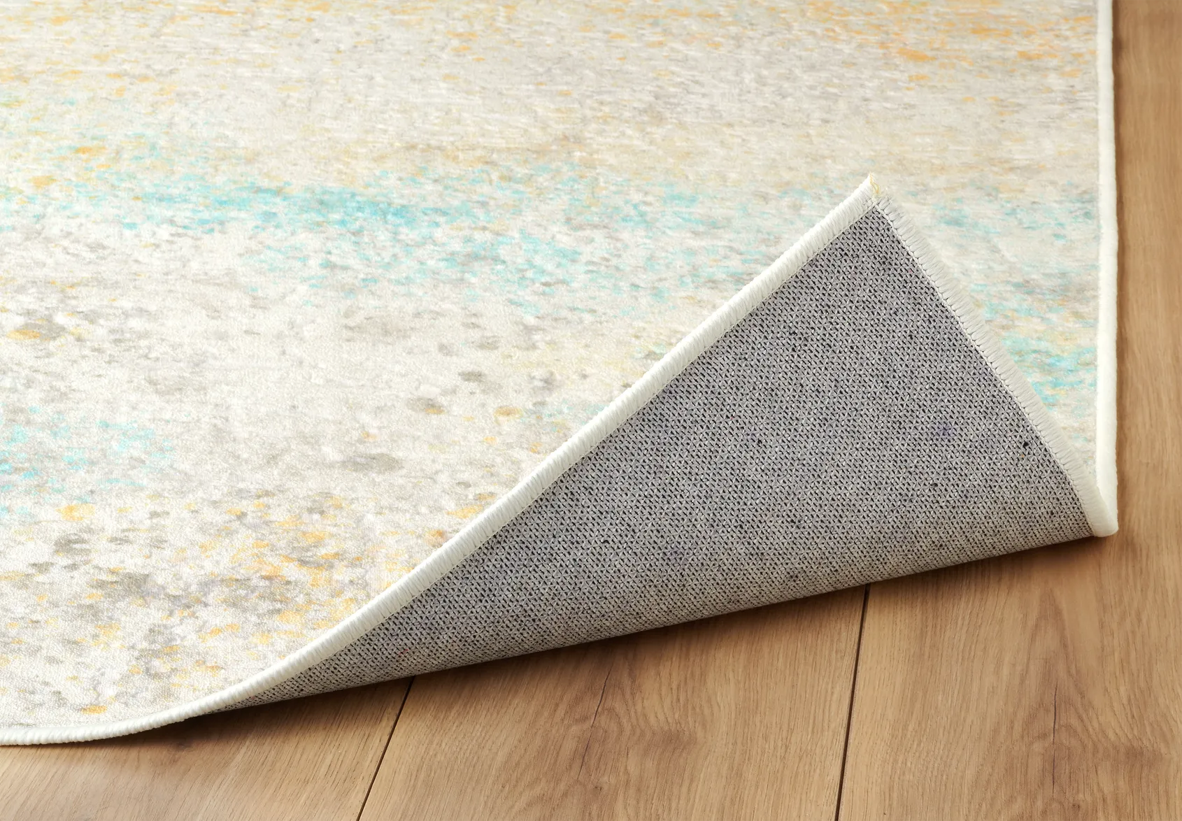 Angolo del tappeto Fioralys bouclé 3D con bordo rifinito e retro antiscivolo.