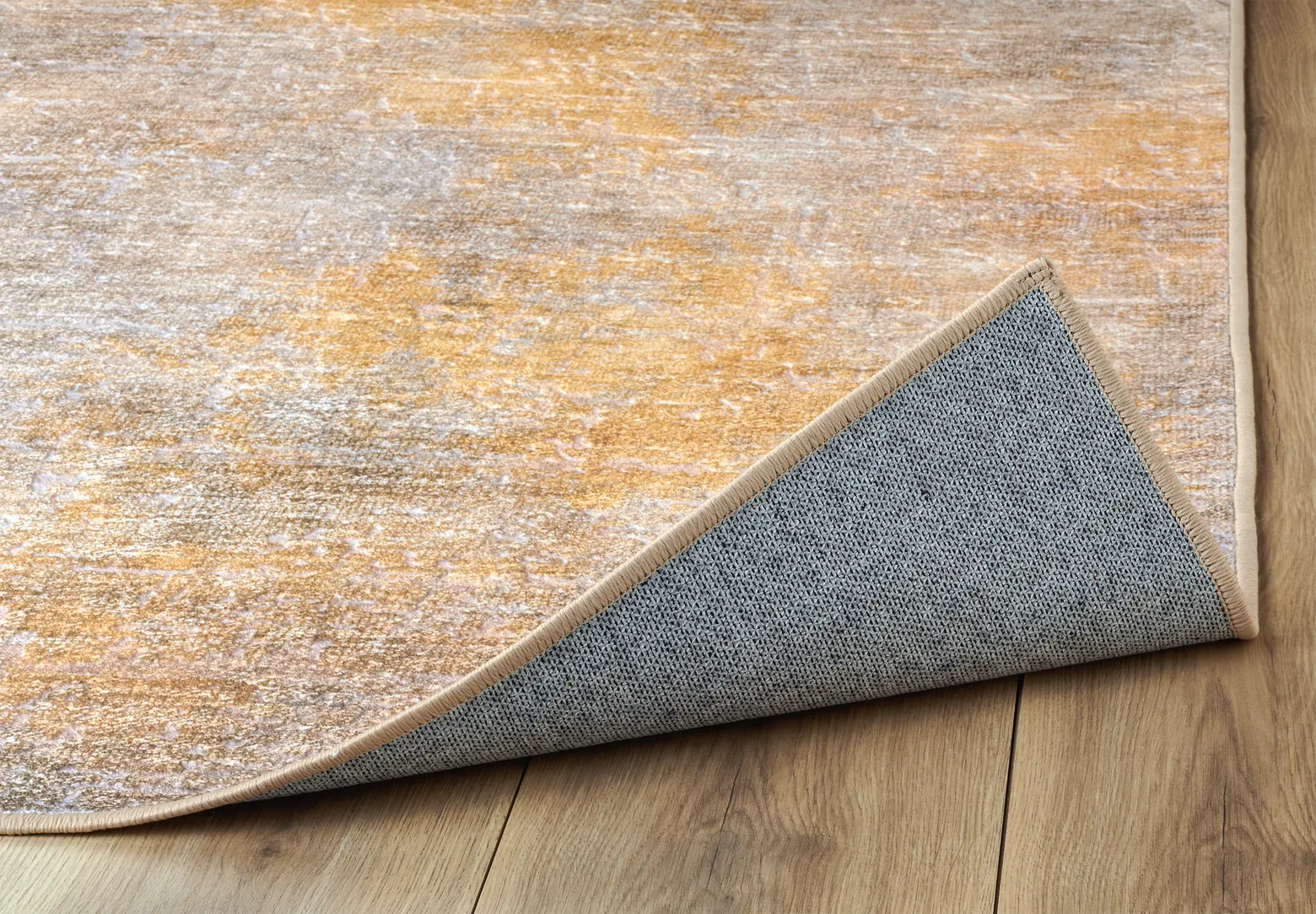 Angolo del tappeto Onis Gold bouclé 3D con bordo rifinito e base antiscivolo.
