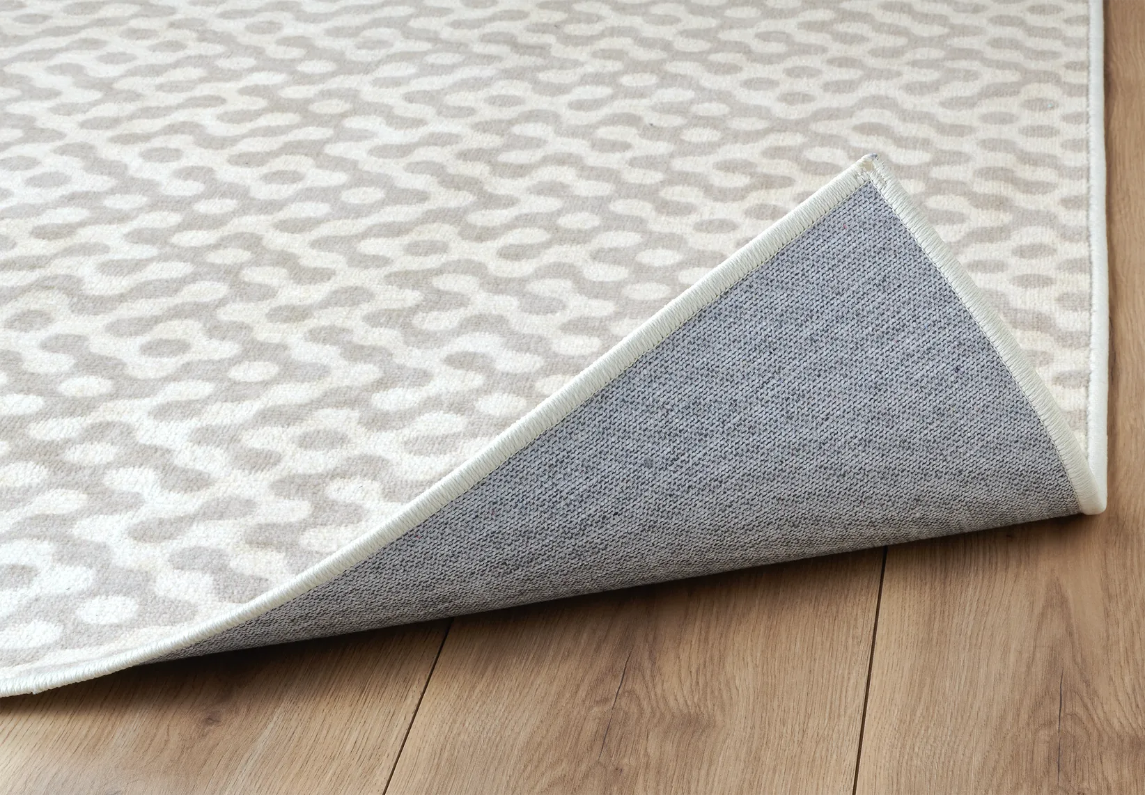 Angolo del tappeto Haral in pelo taftato con bordo rifinito e retro antiscivolo.