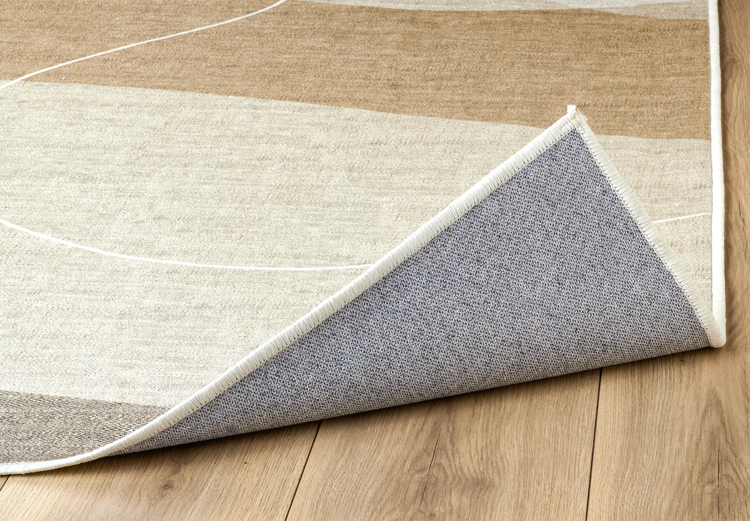 Dettaglio angolo del tappeto Dunis con bordo rifinito e base antiscivolo.