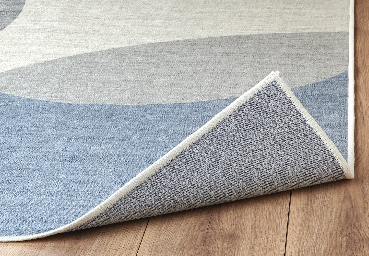 Angolo tappeto Nayra con bordo rifinito e fondo antiscivolo.