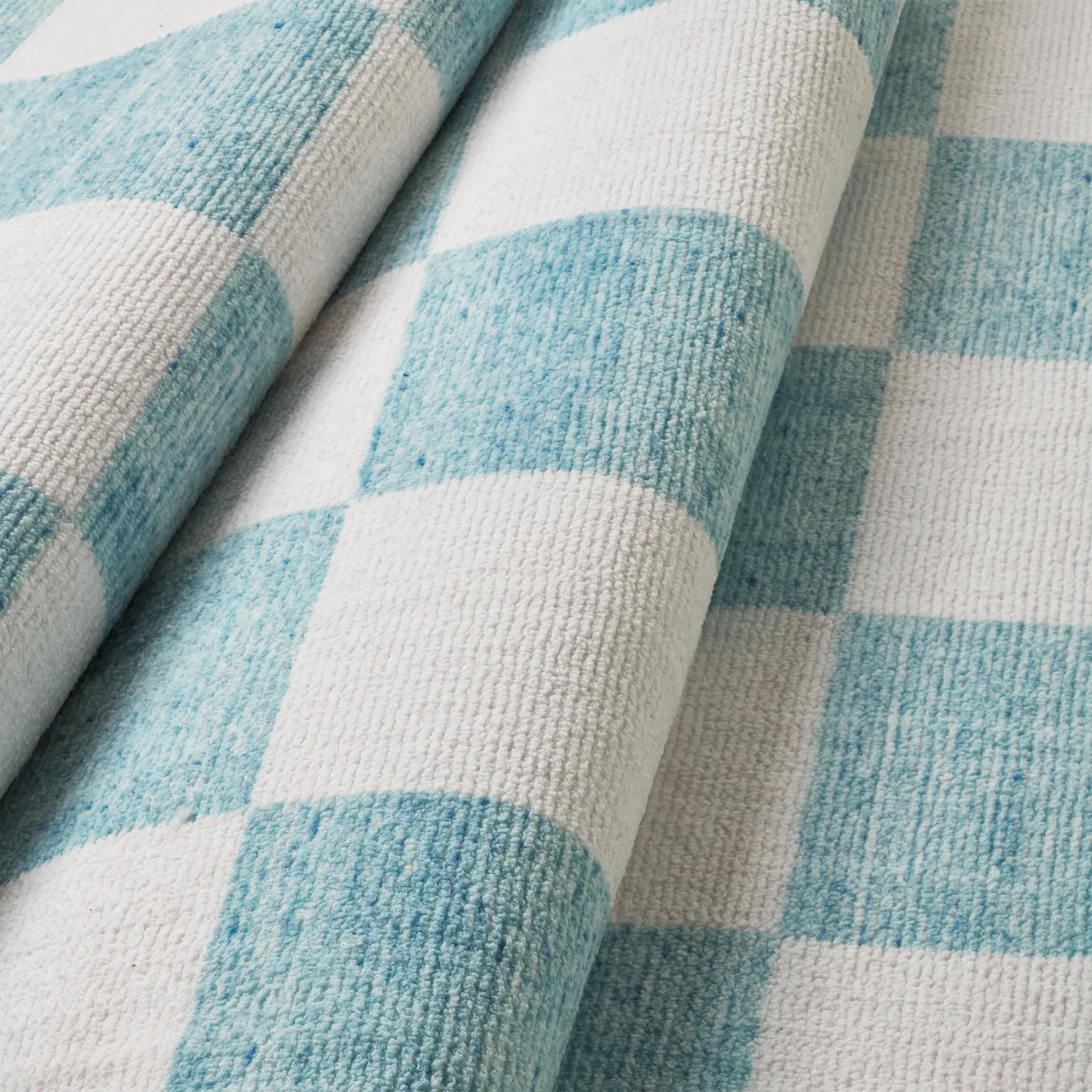 Dettaglio onda del tappeto Jack Mint in pelo taftato, superficie soffice effetto velluto nei toni verde menta e avorio.