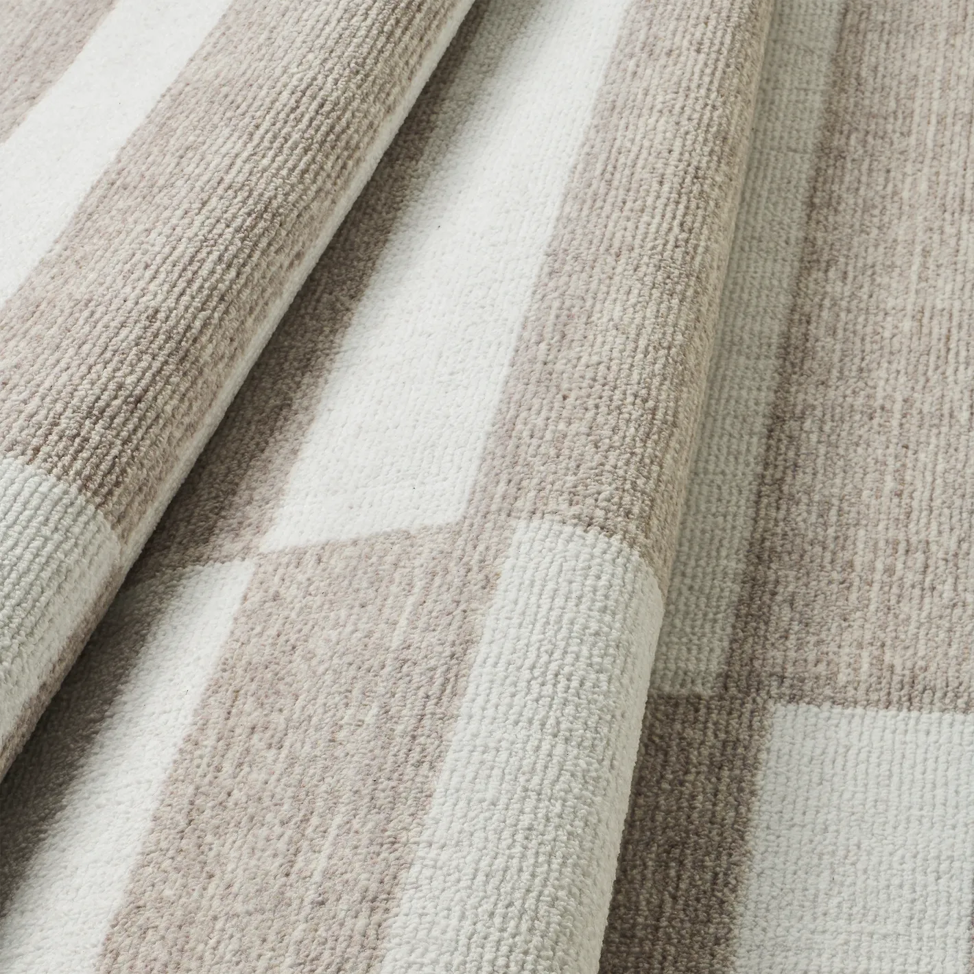 Dettaglio onda del tappeto Strider Grey in pelo taftato effetto velluto, righe orizzontali alternate, tono su tono beige e panna.