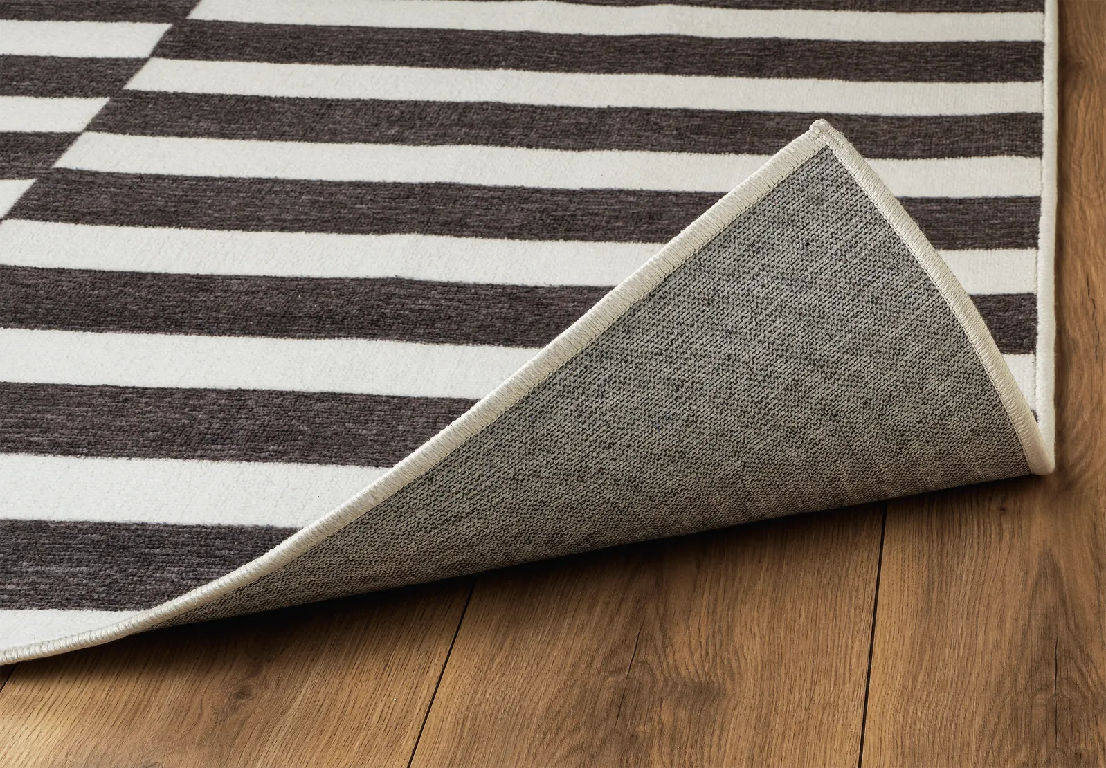 Angolo del tappeto Strider Black in pelo taftato con bordo rifinito e retro antiscivolo.