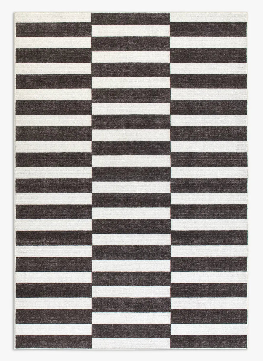 Tappeto Strider Black 160×230 cm in pelo taftato, motivo regolare a righe orizzontali alternate nere e panna su tutta la superficie, visto dall’alto.