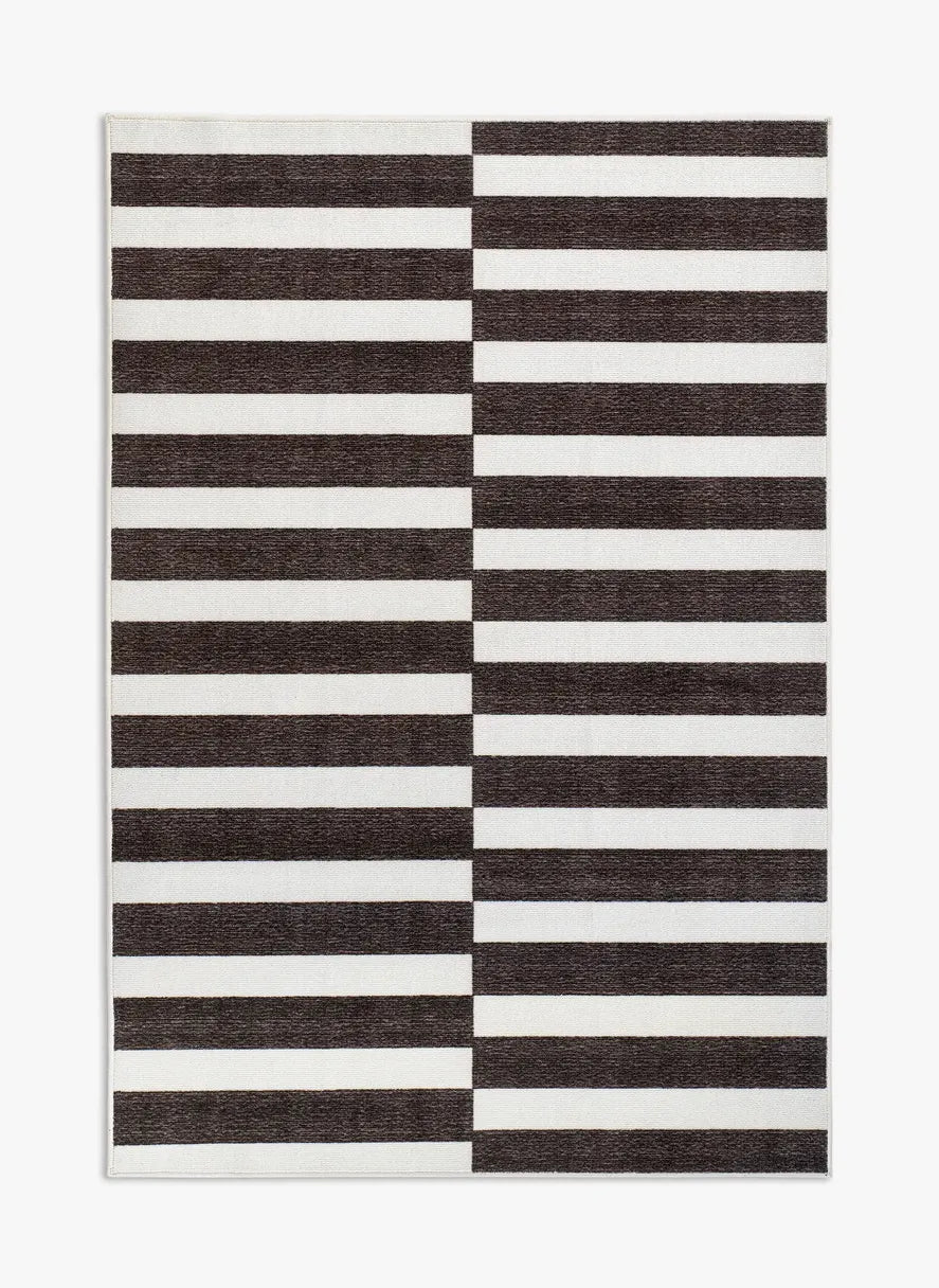 Tappeto Strider Black 130×190 cm in pelo taftato, righe orizzontali alternate nere e panna con effetto a colonne sfalsate, visto dall’alto.