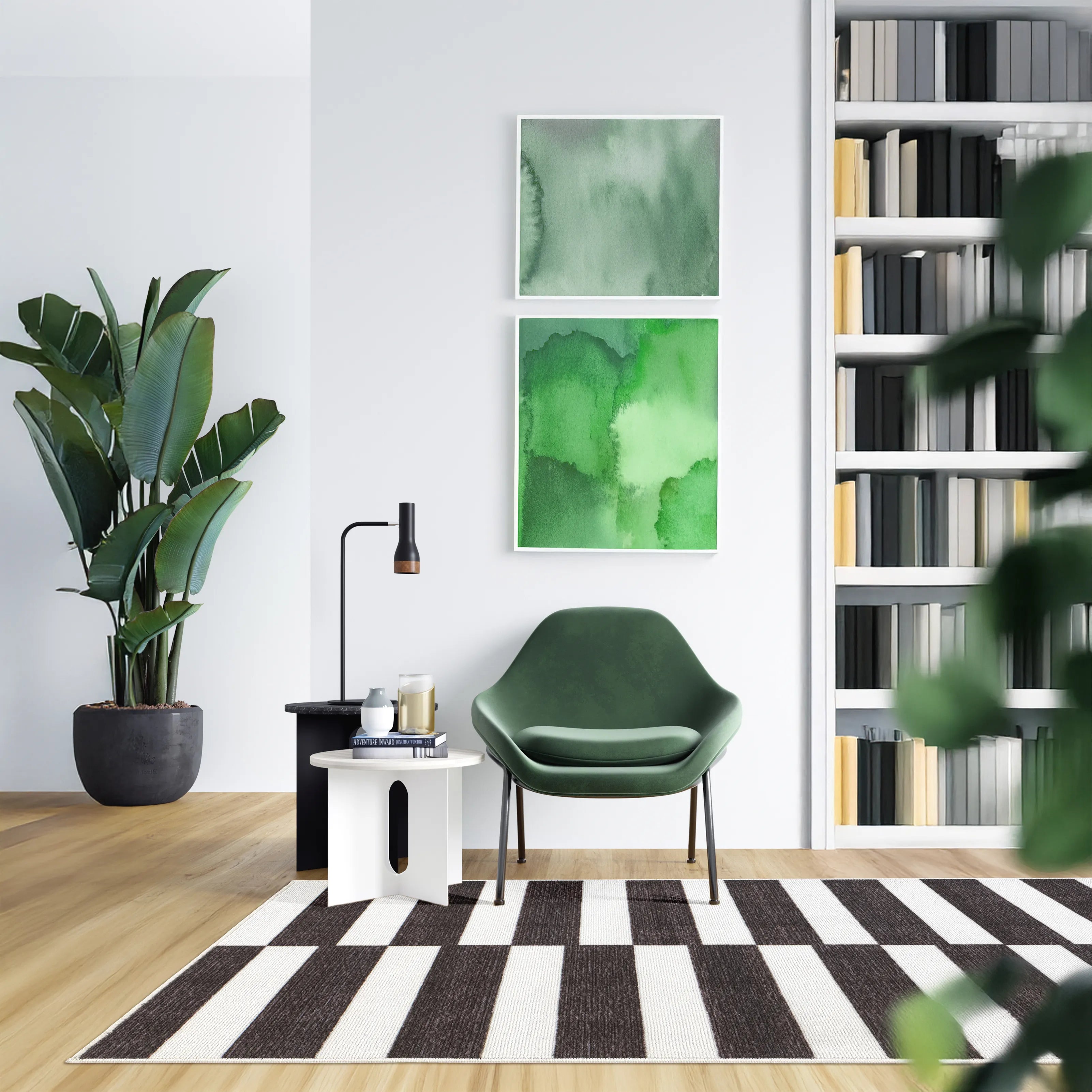 Tappeto Strider Black 80×150 cm a righe nere e panna alternate in angolo lettura con poltrona verde, tavolino bianco, lampada nera, grande pianta in vaso e libreria a parete sullo sfondo.
