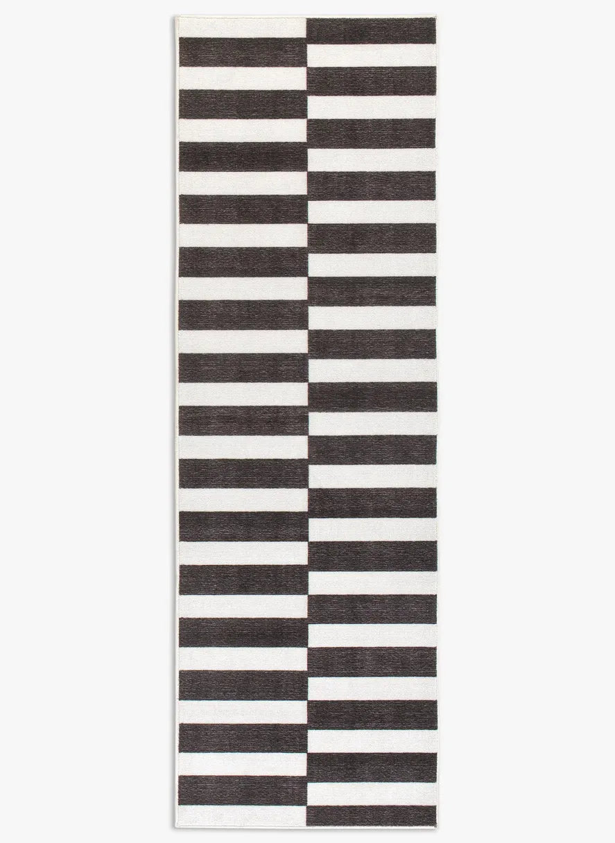 Tappeto Strider Black 80×250 cm in pelo taftato, righe orizzontali allungate alternate nere e panna in colonne sfalsate, visto dall’alto.