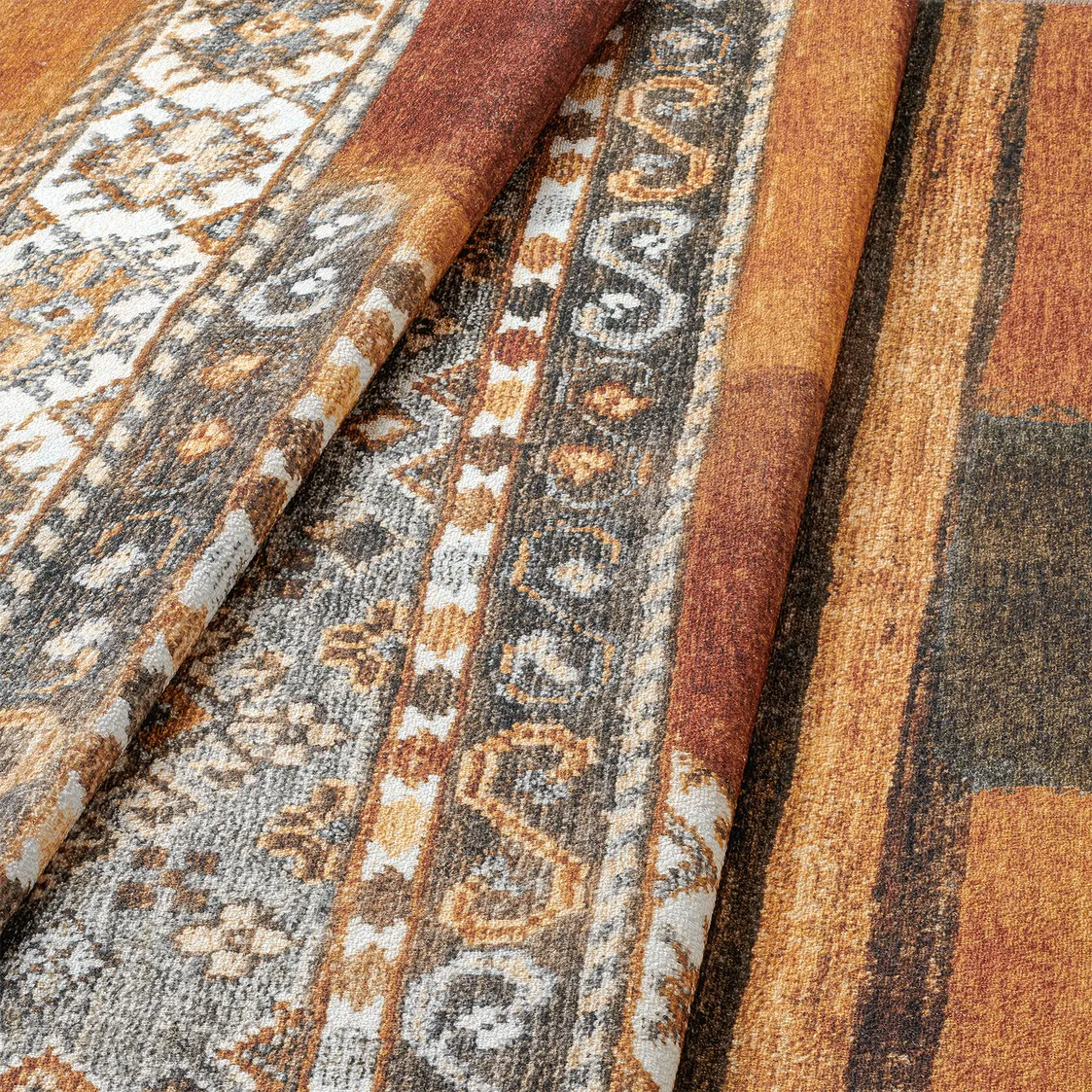 Dettaglio onda del tappeto Myfar, con sfumature terracotta e motivi etnici.