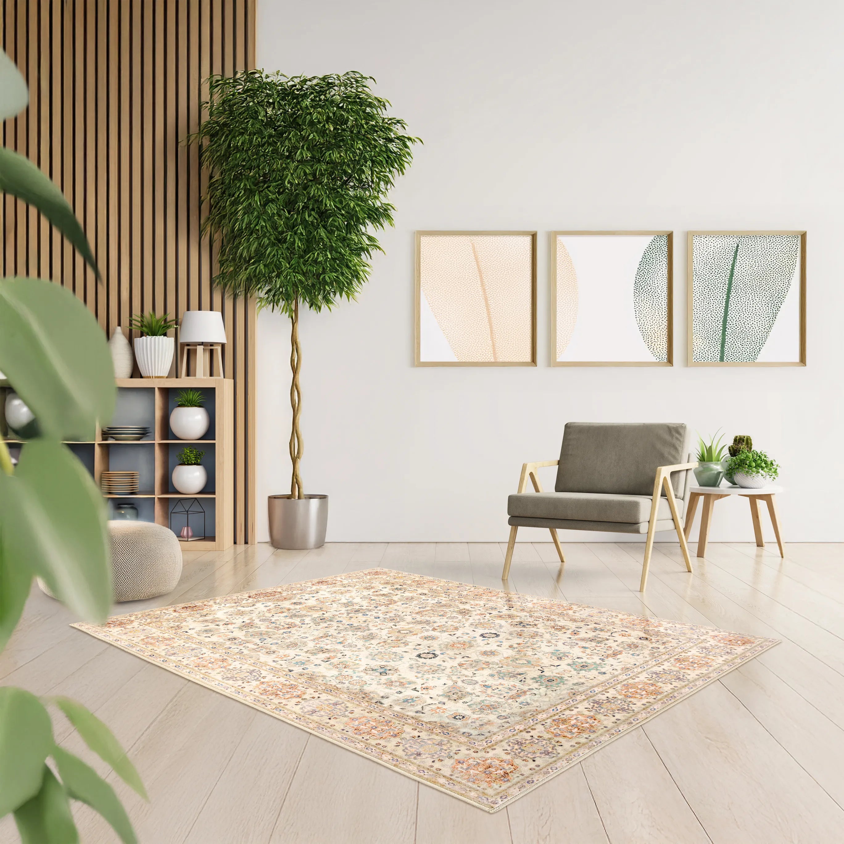 Tappeto Jane 130×190 cm in living moderno con parete a doghe in legno, grande pianta in vaso, poltrona grigia e trio di quadri astratti dai toni soft.