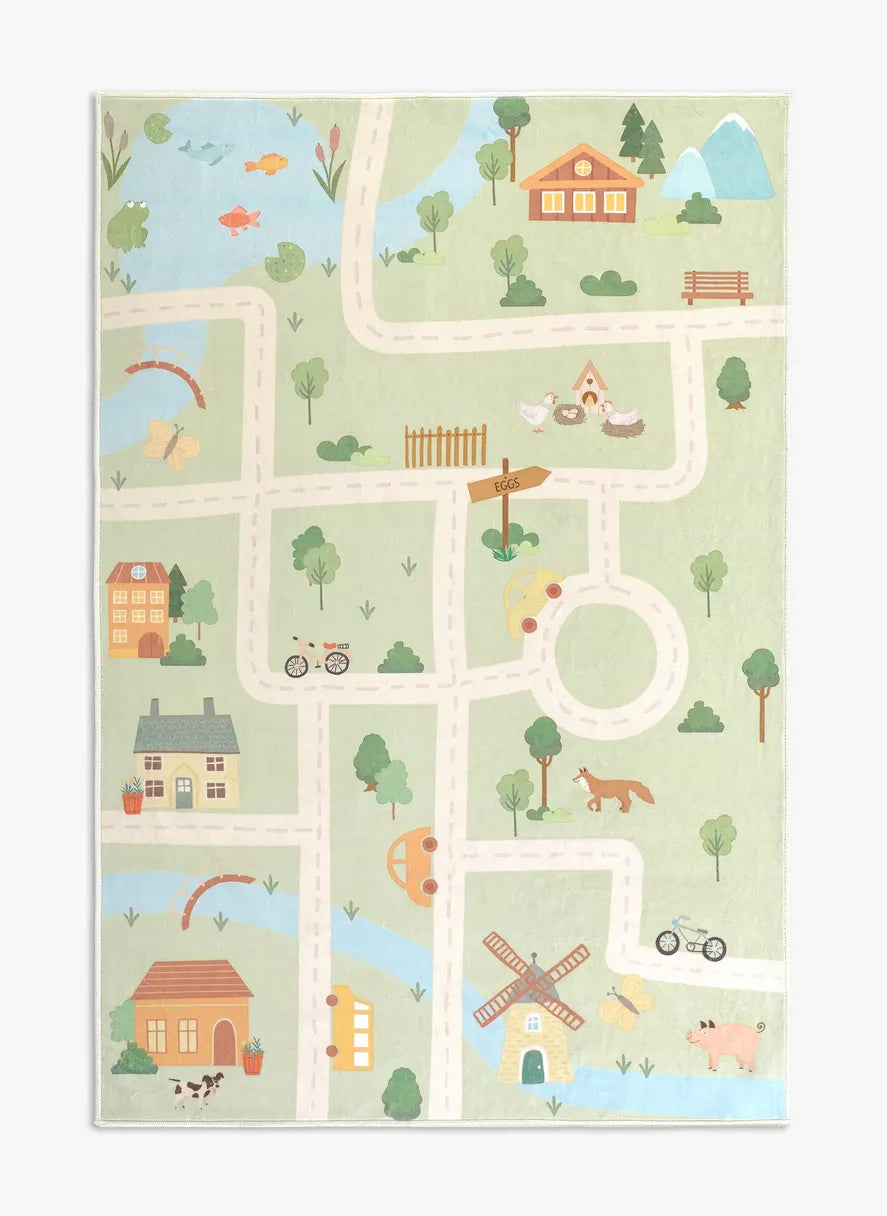 Tappeto Ecovia 120×180 cm in pelo corto di microfibra con mappa illustrata di strade bianche, casette colorate, alberi e laghetti su fondo verde, visto dall’alto.