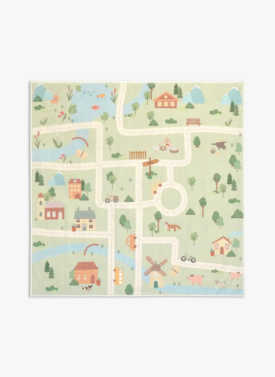 Tappeto Ecovia 120×120 cm in microfibra, formato quadrato con percorso di strade che collega casette, alberi e corsi d’acqua su sfondo verde chiaro, visto dall’alto.