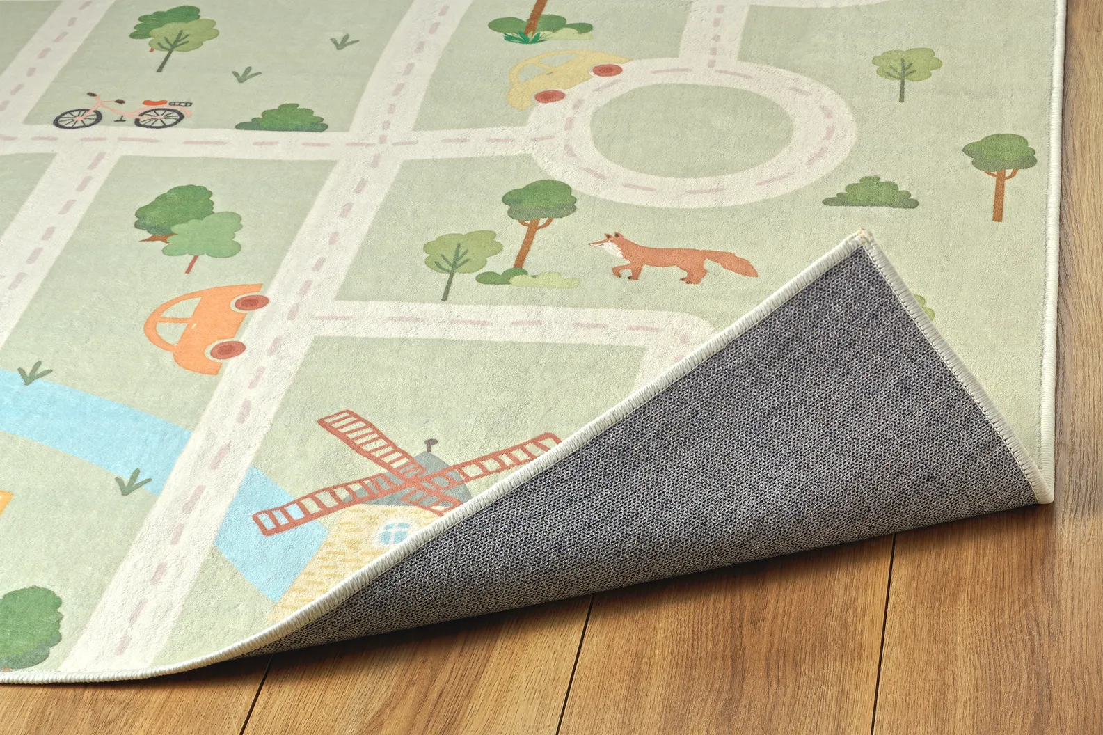 Angolo del tappeto Ecovia con bordo rifinito, porzione di illustrazione e retro antiscivolo.