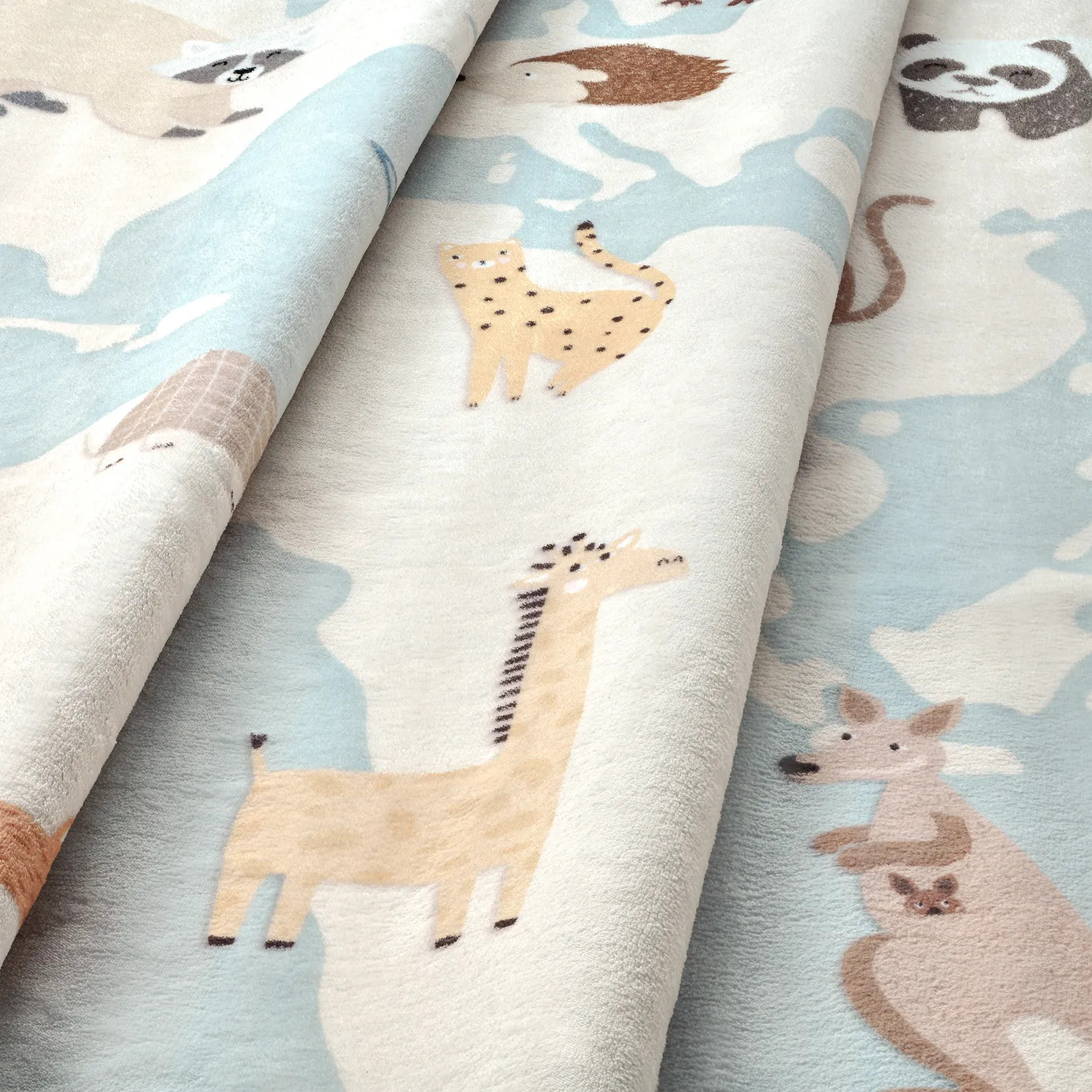 Dettaglio onda del tappeto Zoonia in pelo corto di microfibra, superficie morbida con stampa di oceano azzurro, continenti e animali.