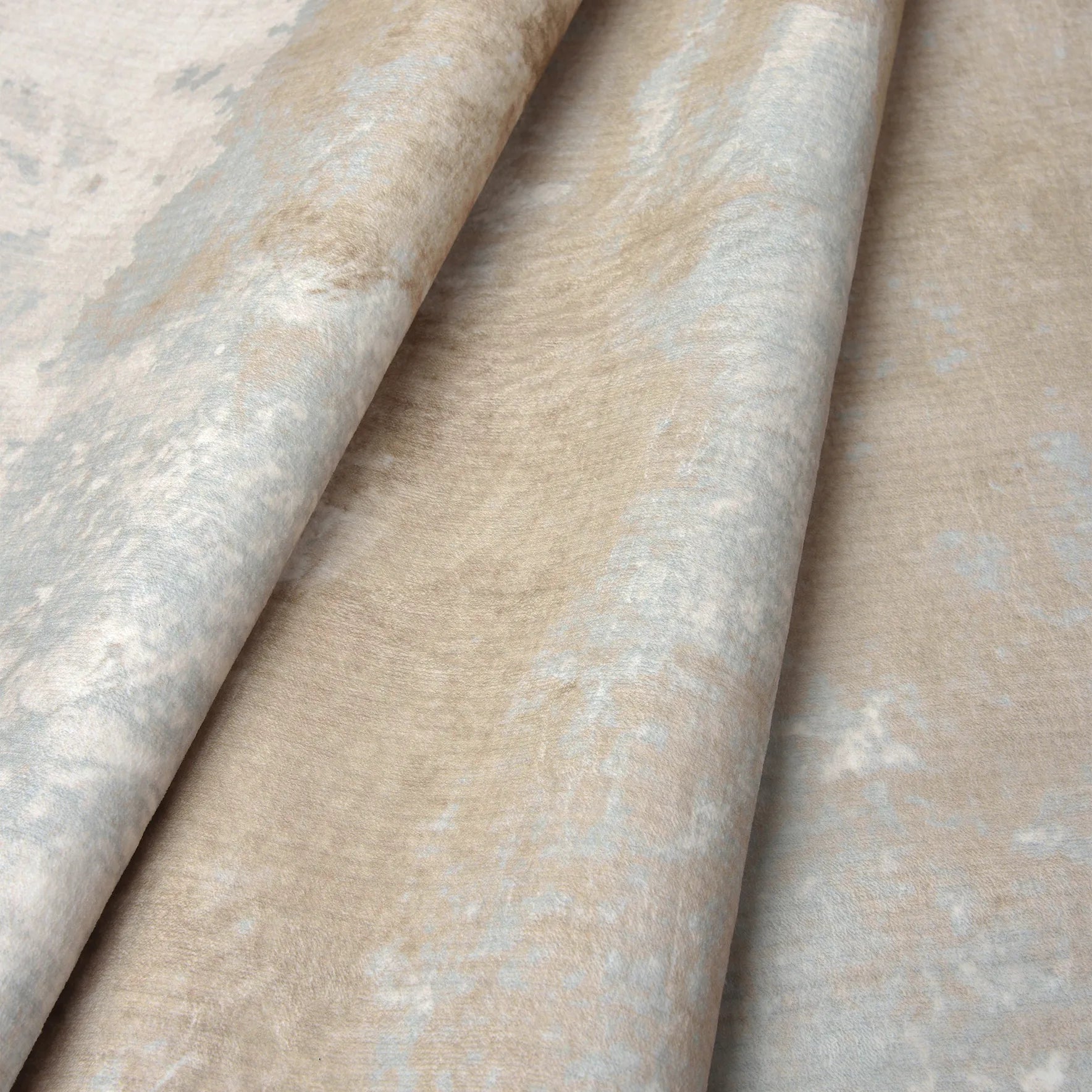 Dettaglio del tappeto Argon: velluto a pelo corto con effetto marmo nelle tonalità tortora, avorio e tocchi grigio-azzurri.