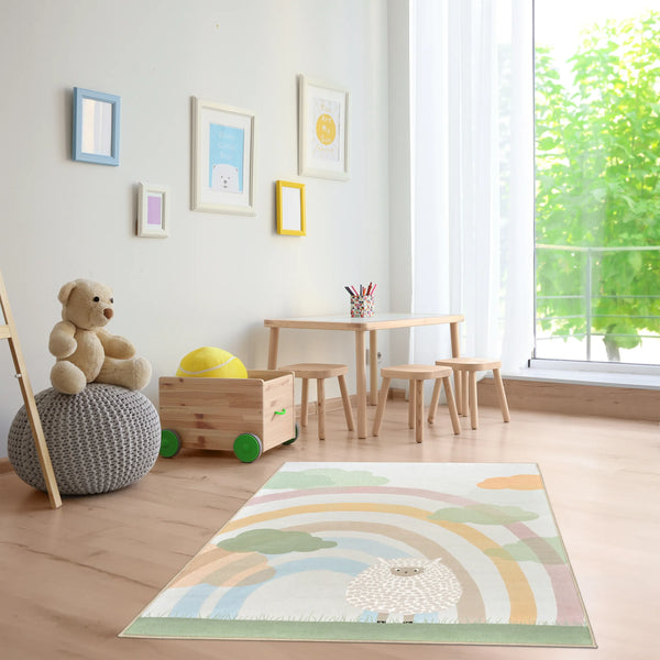 Tappeto Bella 120×180 cm in cameretta luminosa con tavolino rotondo e sgabellini in legno vicino a grande finestra con tende chiare; pouf grigio con orsetto e carrellino giochi; lavabile in lavatrice a 40° e asciugabile in asciugatrice, antimacchia, antiscivolo e impermeabile.