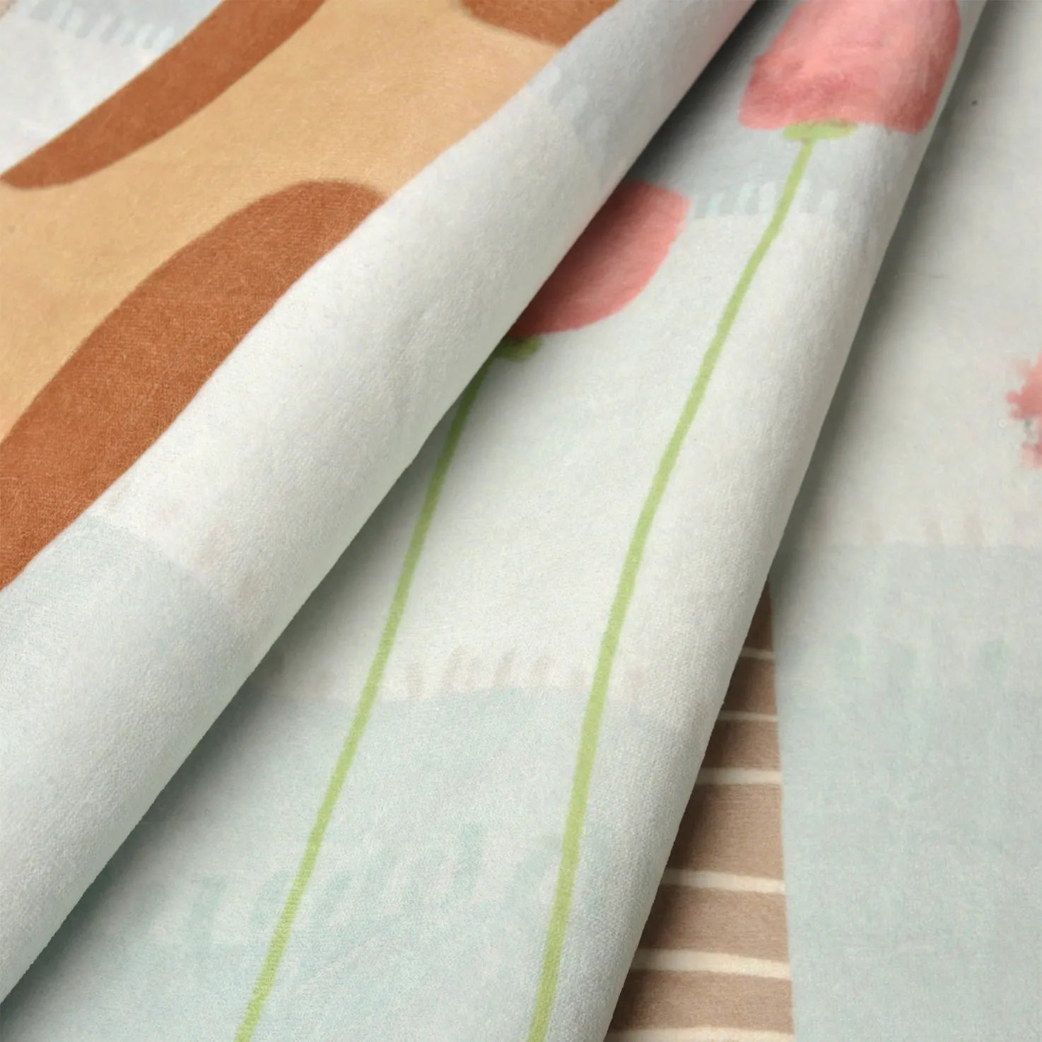 Dettaglio del tappeto Gaffy: microfibra vellutata a pelo corto con stampa pastello nitida di fiori e giraffa.