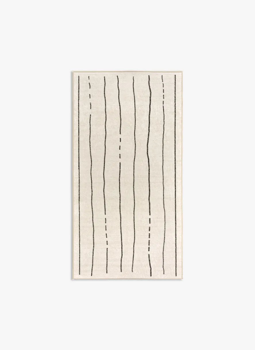 Tappeto Lead 80×150 cm crema con righe nere; lavabile in lavatrice a 40° e asciugabile in asciugatrice, antimacchia e antiscivolo.