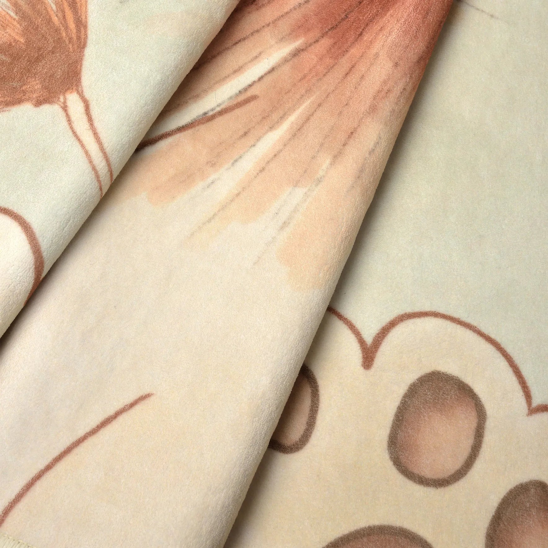 Dettaglio del tappeto Leon: velluto a pelo corto con stampa morbida della criniera e delle zampette in toni avorio e terracotta.