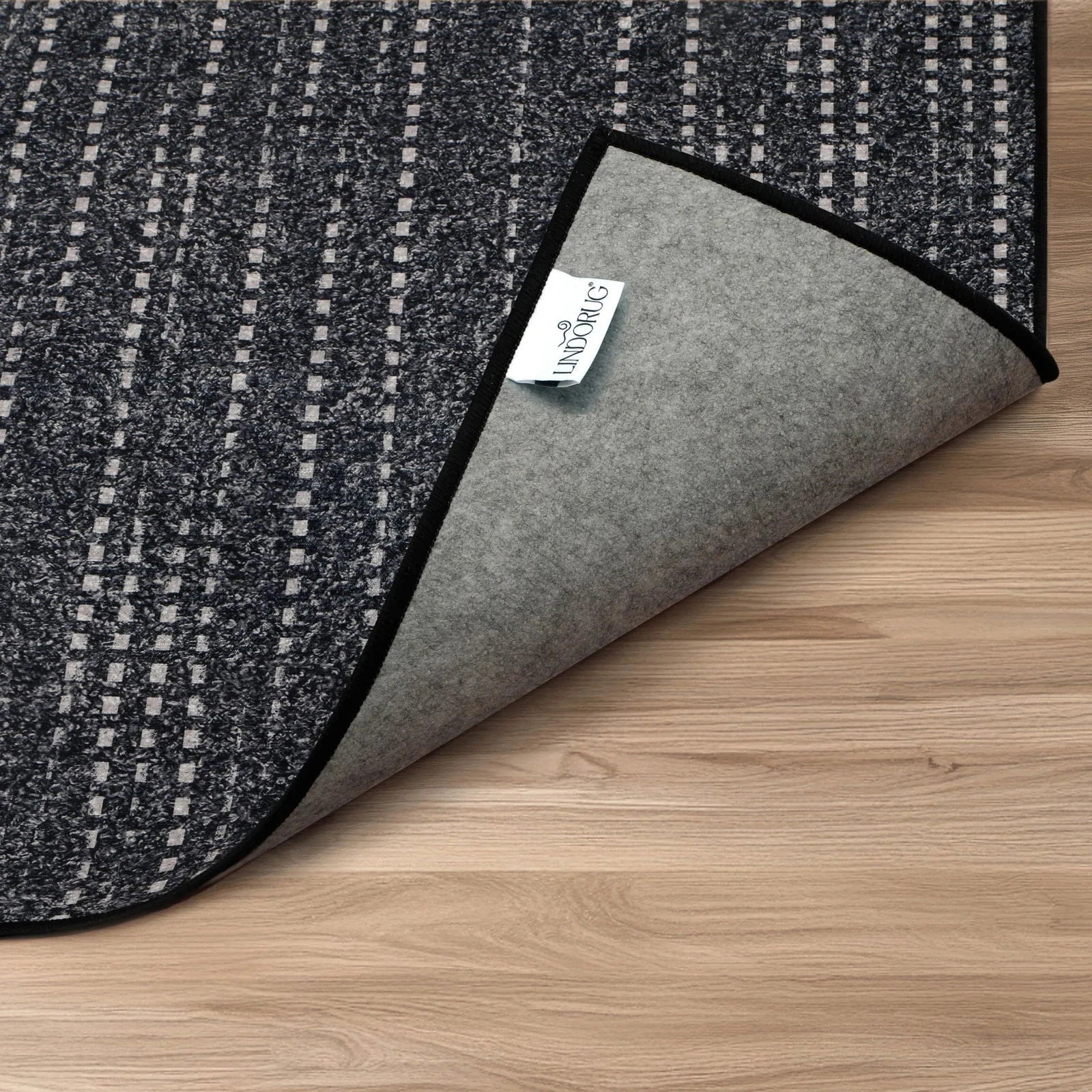 Particolare dell’angolo piegato con etichetta Lindorug, retro antiscivolo con finitura leva grigio