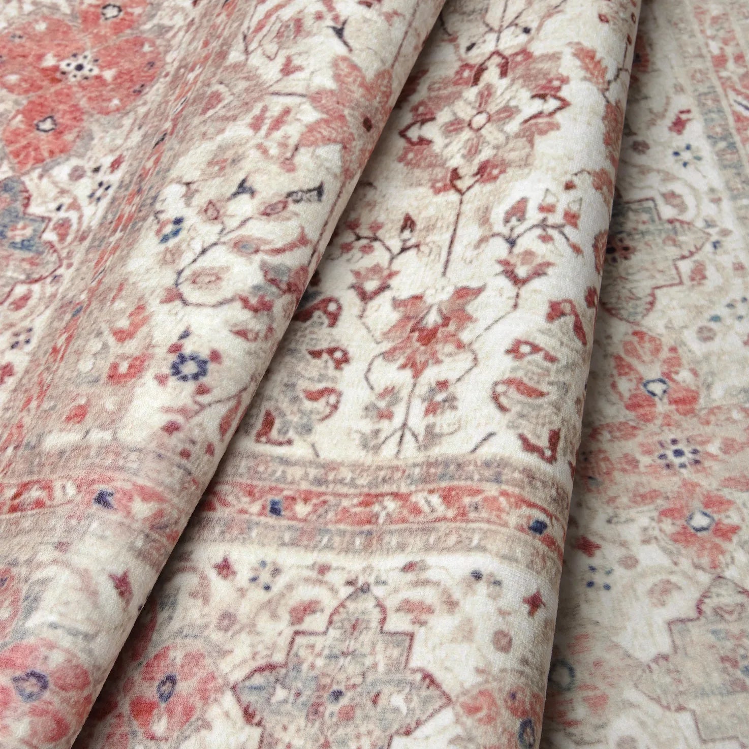 Dettaglio ravvicinato del tappeto Sindhi in ecru e corallo: trama morbida con motivo floreale orientale che evidenzia i particolari del design.