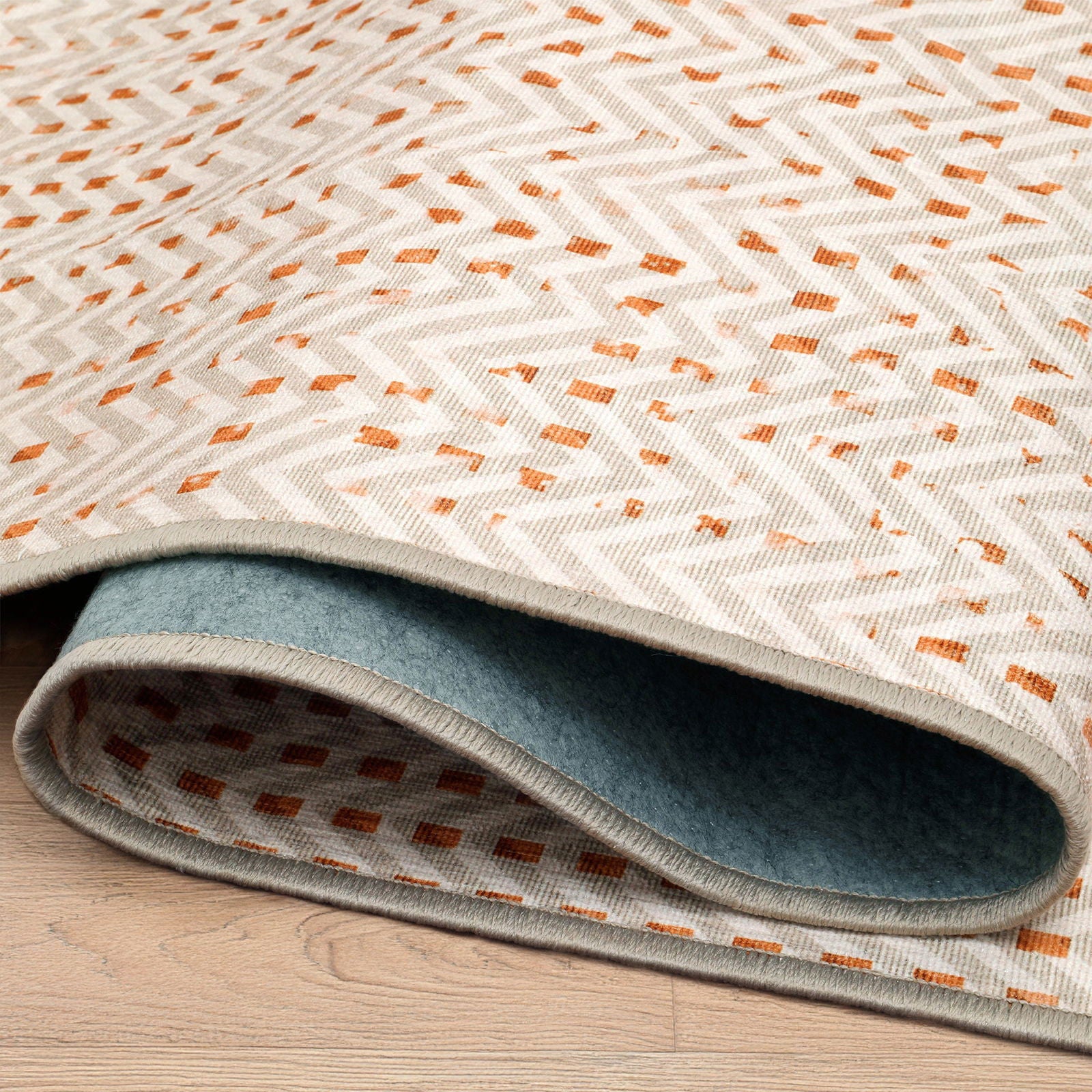 Dettaglio arrotolato tappeto Tang collezione Chenny mostra retro antiscivolo e orlo