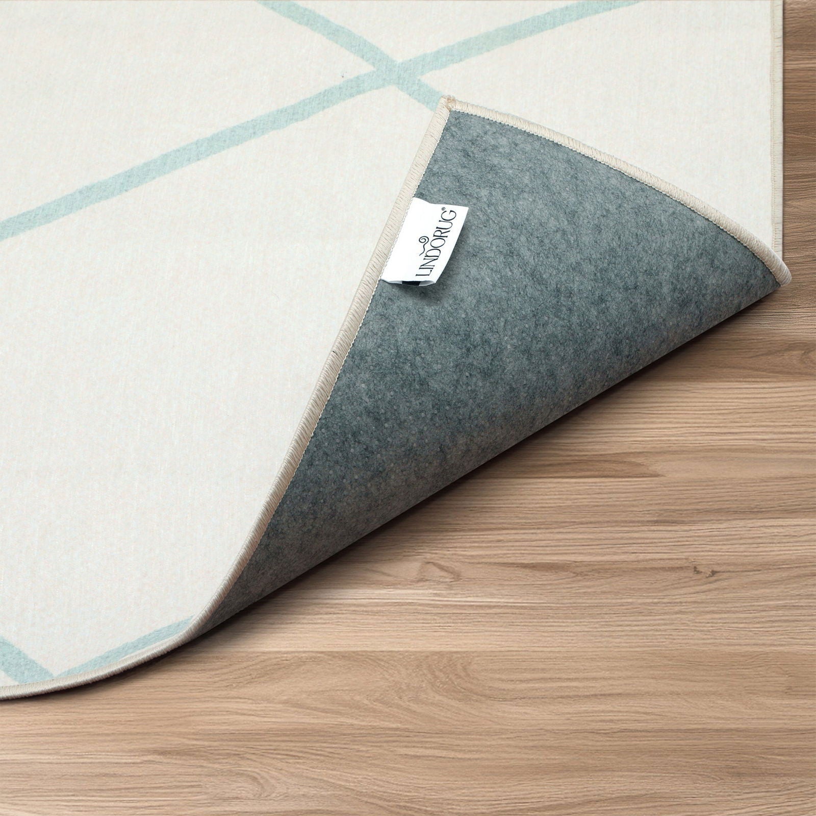 Dettaglio arrotolato tappeto Ziad collezione Chenny mostra retro antiscivolo ed etichetta con logo Lindorug